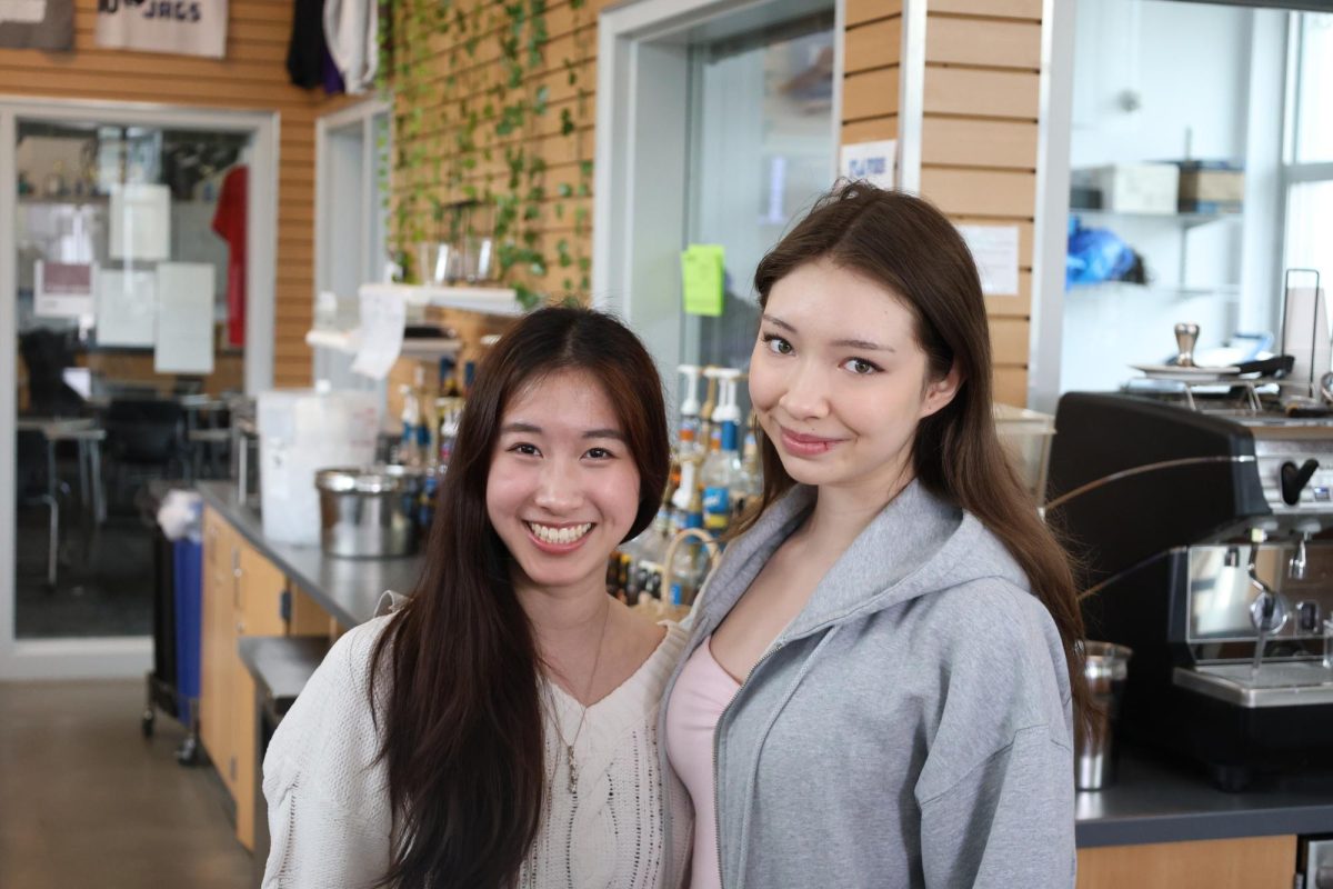 Emma Kao and Isabel Colvin stand in the Den. Kao is the VP of Leadership for DECA.